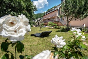Un hotel con jardín, sala de estar y escalera que conduce a los pisos superiores.