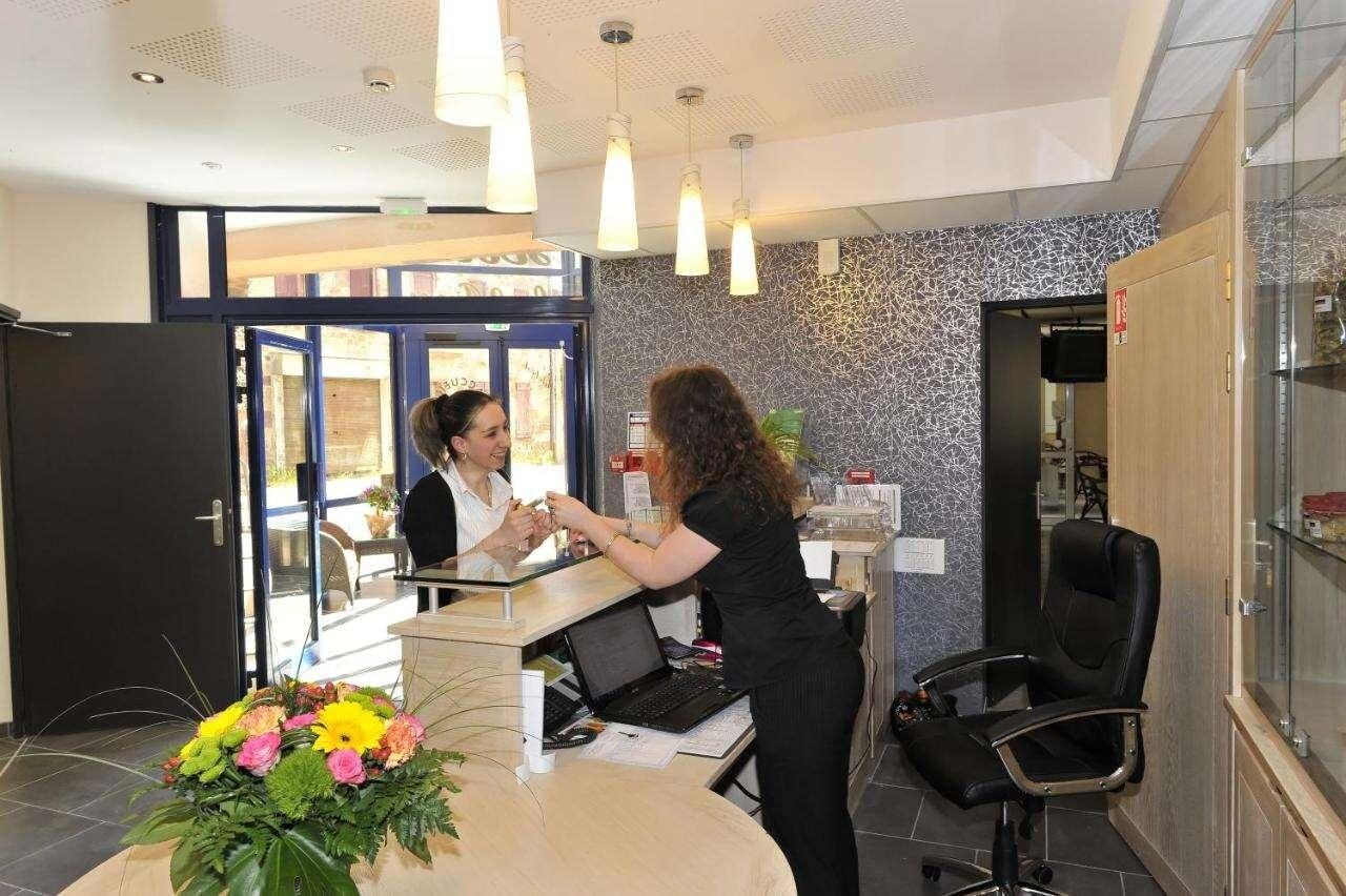A reception area with a desk, chairs, and a large window.