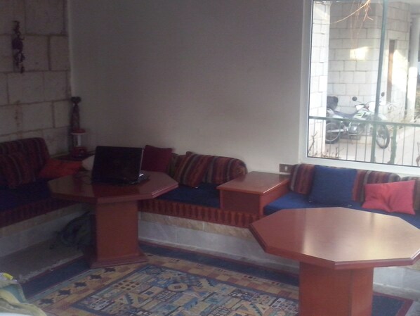 A living room with a sofa set, a coffee table, and a laptop.