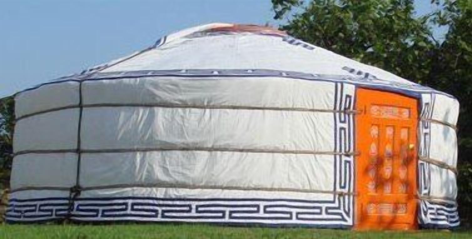 A white yurt with an orange door, surrounded by grass.