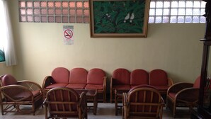 A room with a sofa set, chairs, a painting, and a no-smoking sign. - Hotel Lautze Indah (Jakarta)
