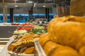 A buffet with various food items including bread, fruits, and vegetables. - Kar Hotel (Mersin)