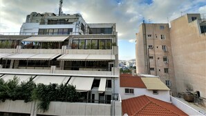 A multi-story building with a flat roof and large windows, surrounded by other buildings. - Hotel Achillion (Piraeus)