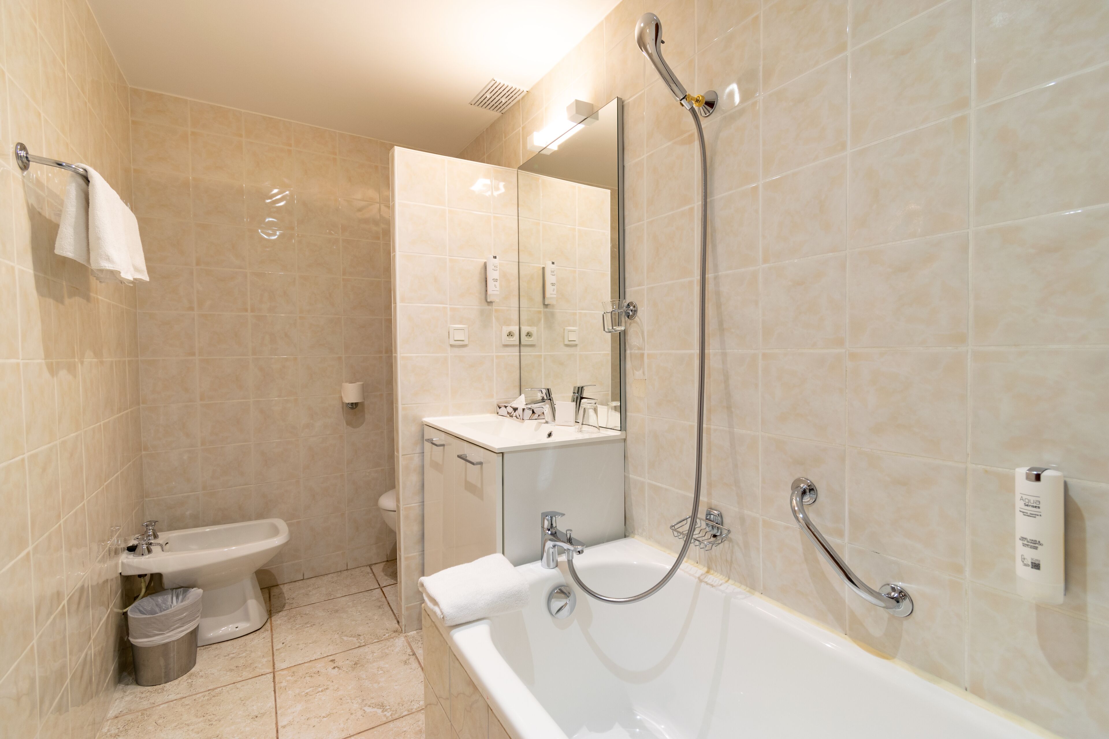 Un baño moderno con bañera, lavamanos e inodoro.