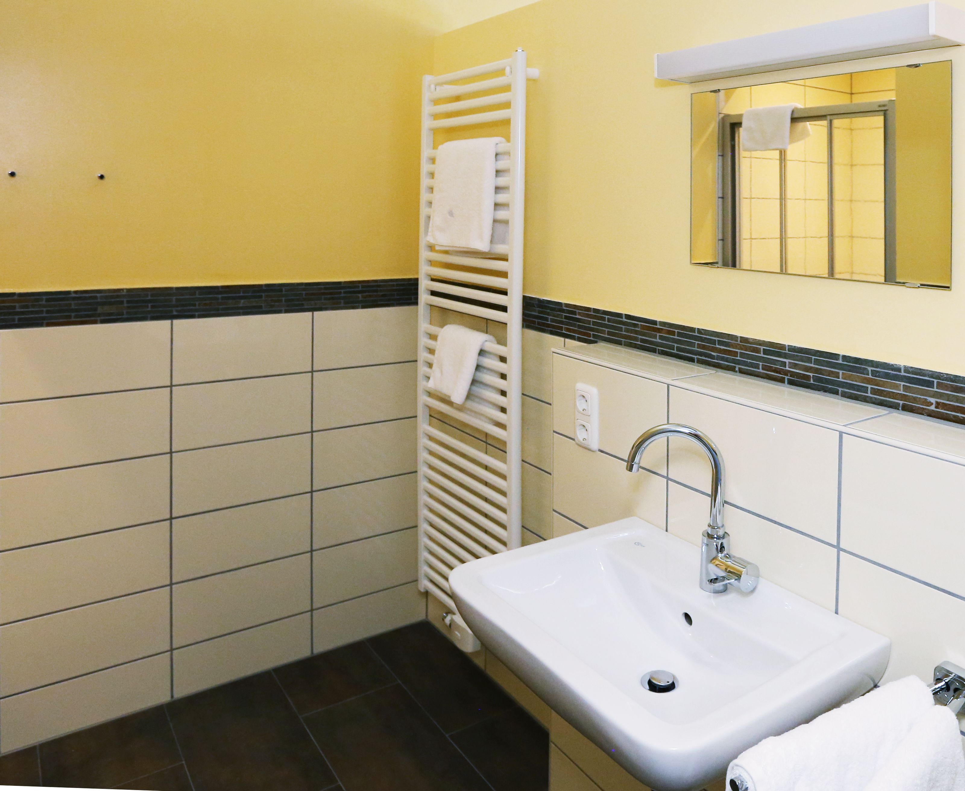A bathroom with a white sink, a towel rack, and a mirror.