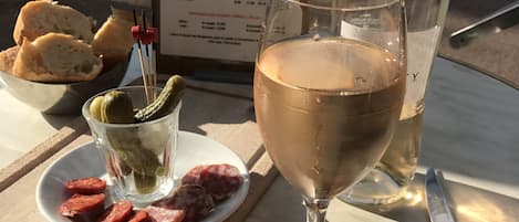 Una mesa con un menú, una copa de vino, un plato de comida y un cuchillo.