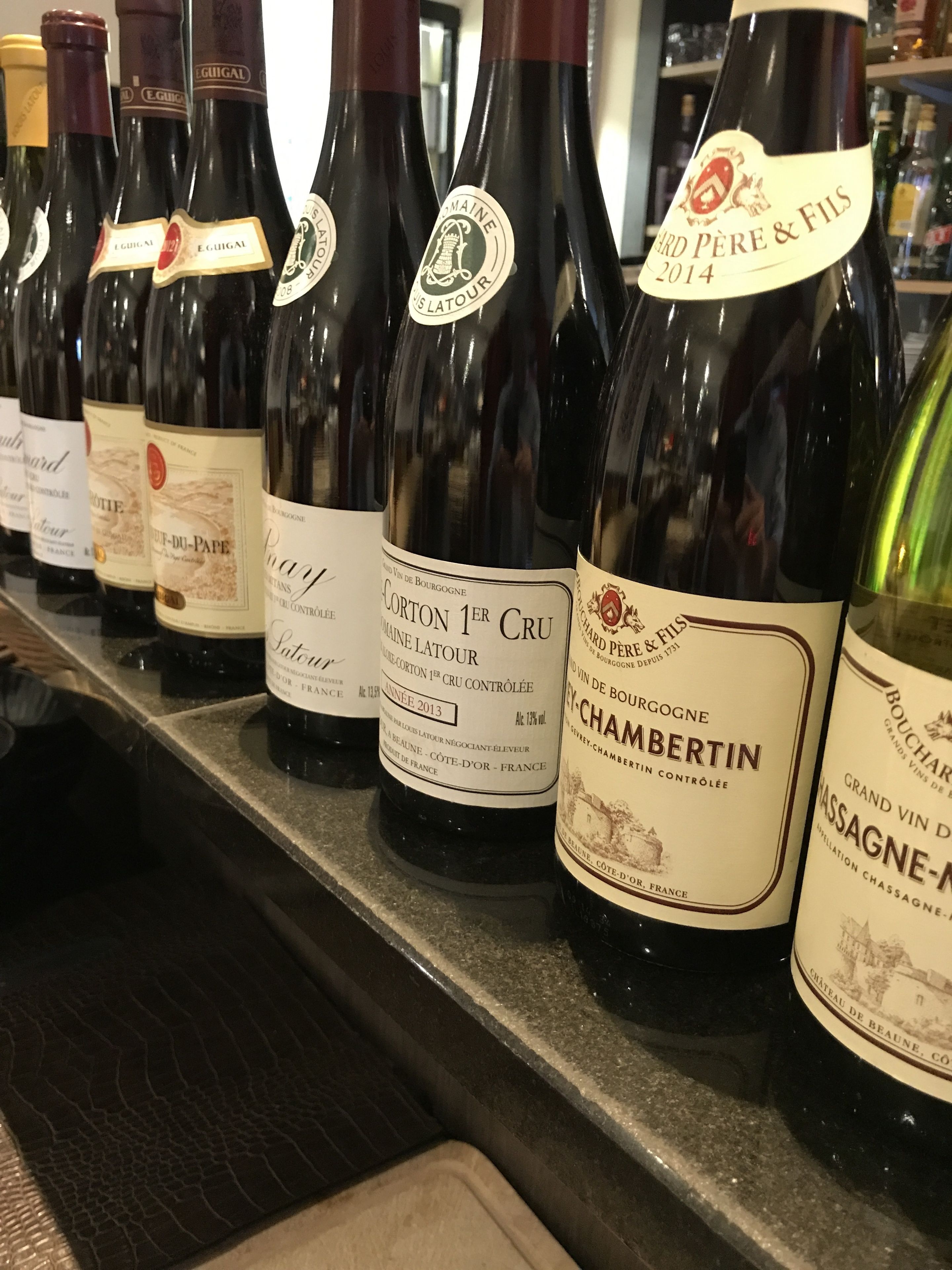 A row of wine bottles on a shelf.