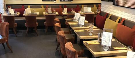 A restaurant interior with booths, tables, and chairs.