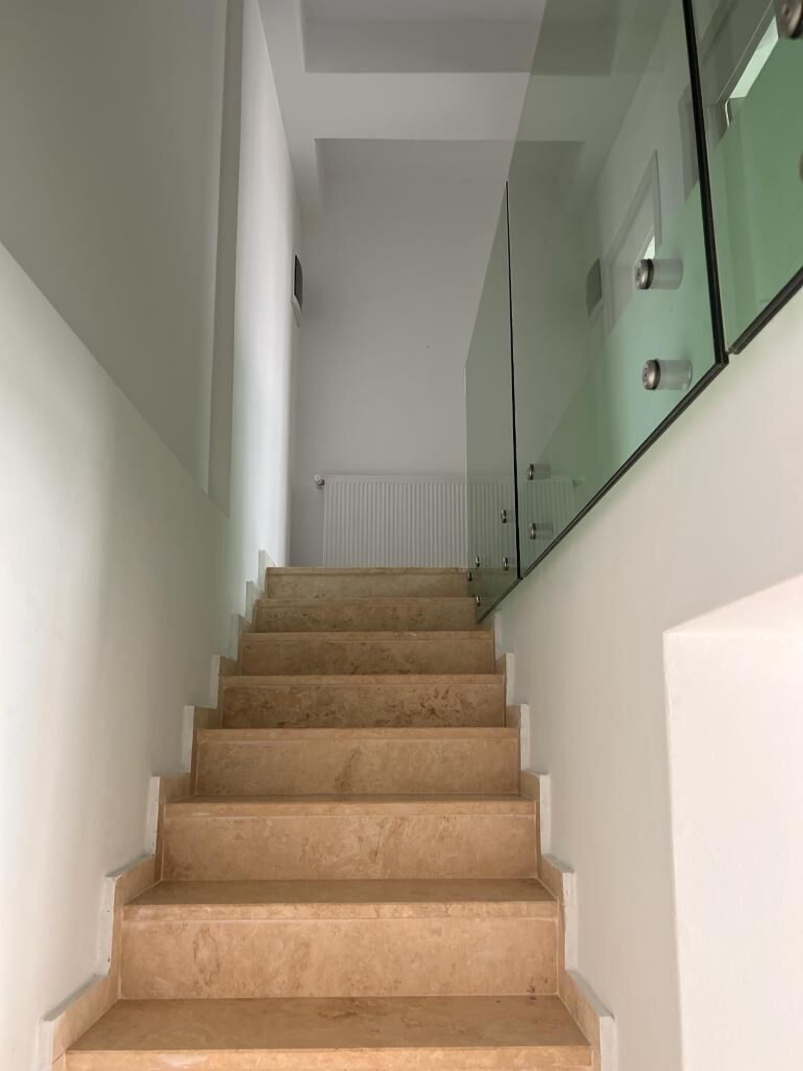 Una escalera con peldaños color beige que conduce a una plataforma.