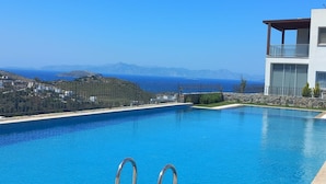 Una piscina con vistas al mar y a las montañas.