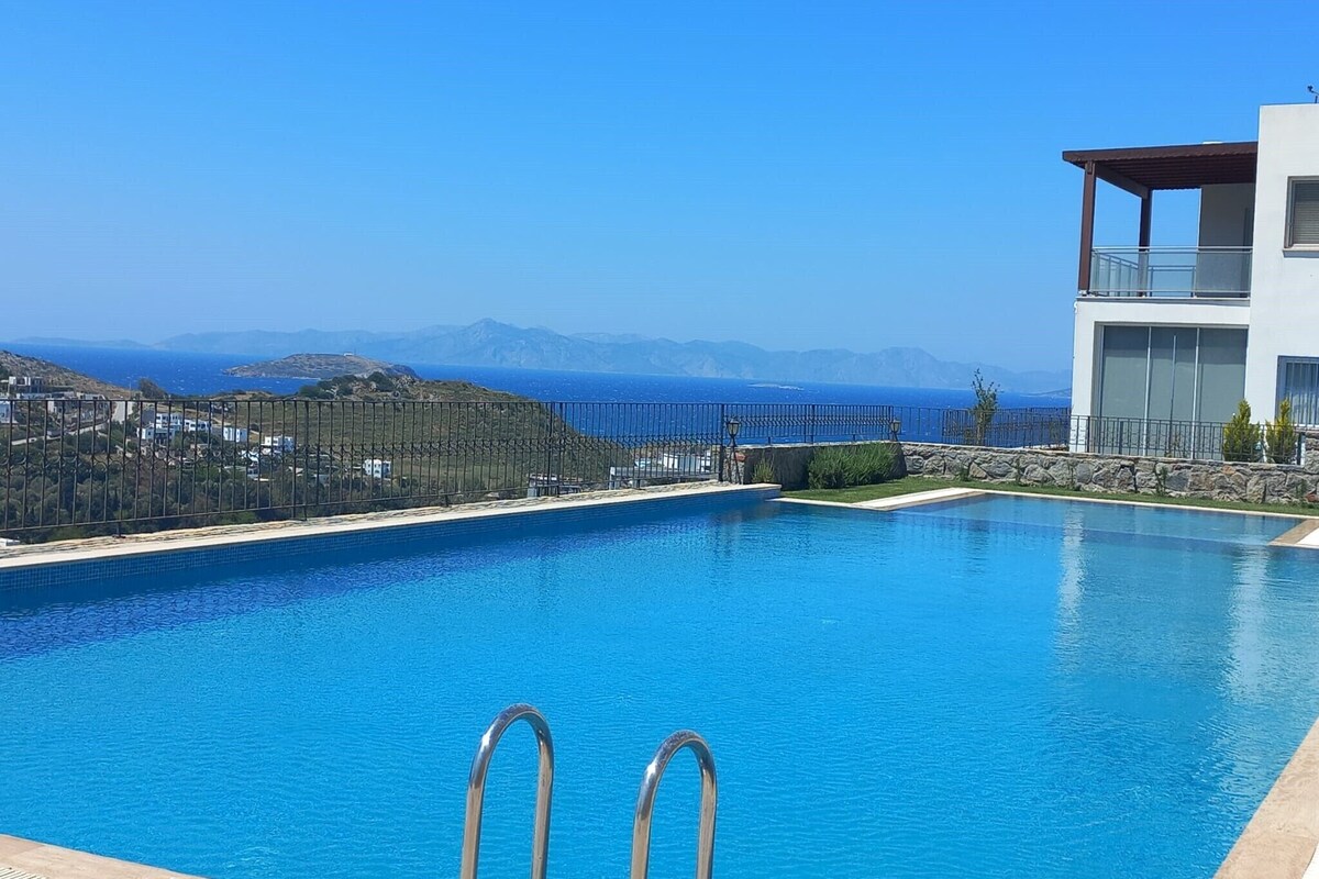Une piscine avec vue sur la mer et les montagnes.