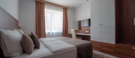 Un dormitorio moderno con cama, escritorio y armario.