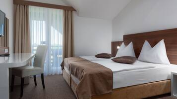 A hotel room with a bed, a desk, and a chair.