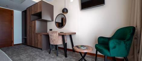 Una habitación moderna con escritorio, silla y un sillón verde.