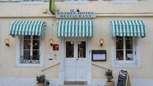 The exterior of the Entree Hotel Restaurant with a green and white striped awning, a signboard, and a chalkboard menu stand. - Hotel Restaurant d'Orfeuil (Bourbonne-les-Bains)