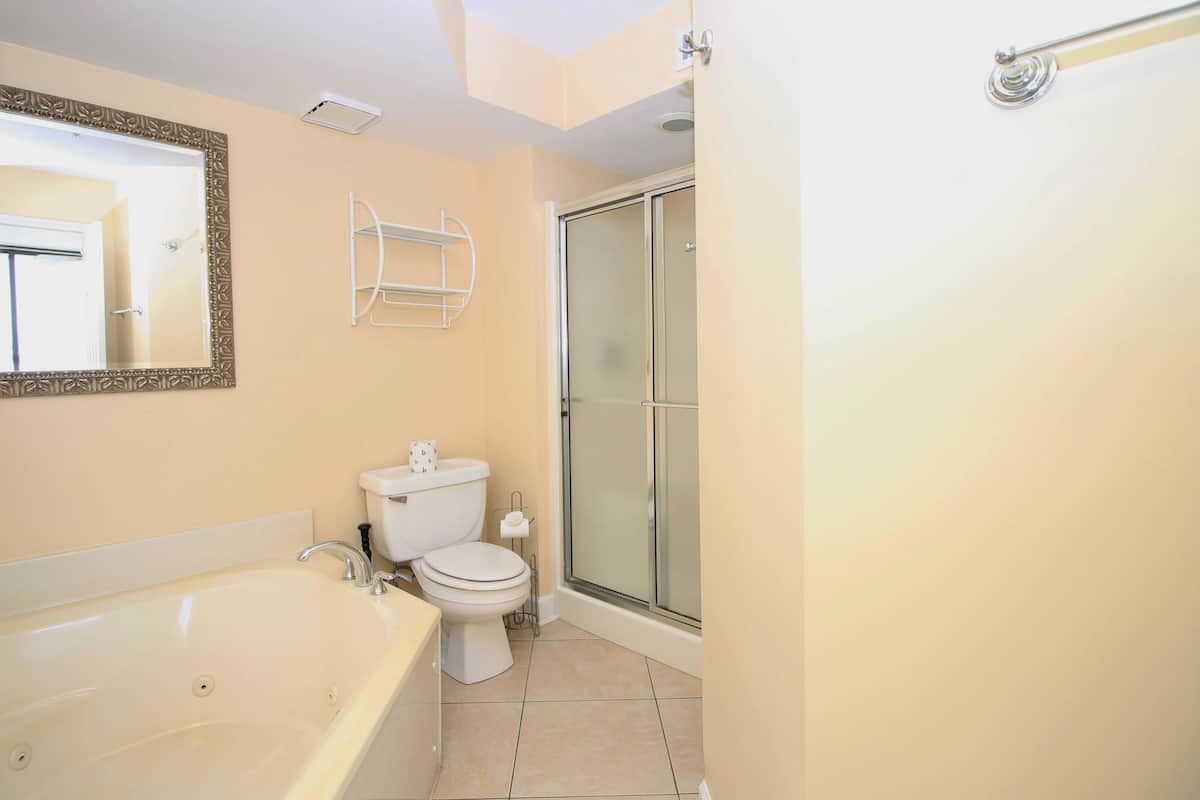 Un baño con bañera, inodoro y cabina de ducha de vidrio.