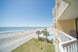 A balcony with a view of a beach and a pool. - Charleston 115 Oceanfront Villas Beach Daze 3 Bedroom Holiday Home By My Ocean Rentals (Folly Beach)