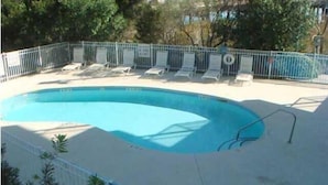 A swimming pool with lounge chairs and a metal fence. - Turn of the River 2G 3 Bedroom Holiday Home By My Ocean Rentals (Folly Beach)