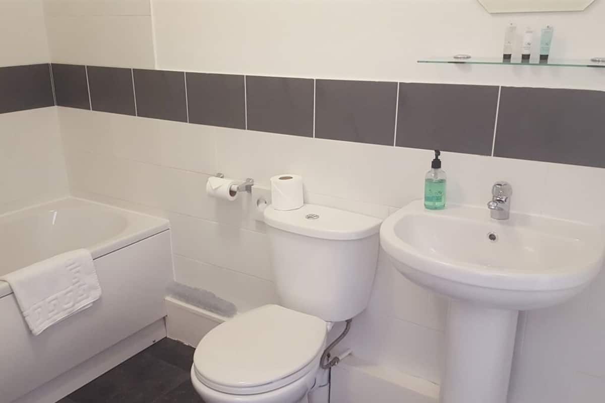 Une salle de bain avec des toilettes, un lavabo et une baignoire.