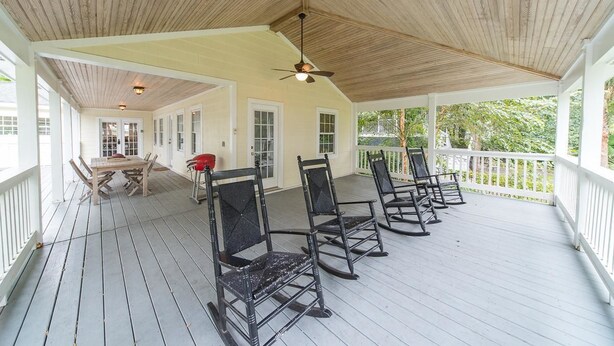 A covered porch with a wooden ceiling, white railings, and a table with chairs. - E Huron 308 4 Bedroom Holiday Home By My Ocean Rentals (Folly Beach)