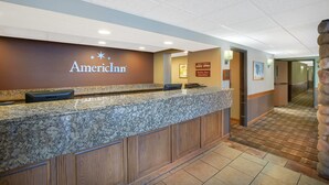 Ein Empfangsbereich mit einer Marmor-Theke, einem Schild mit der Aufschrift "American Inn" und einer Holzsäule.