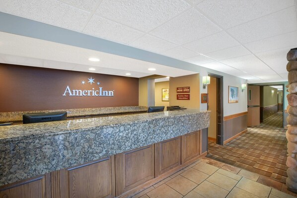 En reception med en marmorskiva, en skylt med texten ”American Inn” och en träpelare.