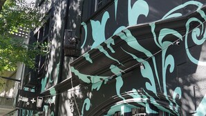 A building with a dark facade and teal decorative elements. - Art Factory Beer Garden - Hostel (Buenos Aires)