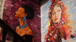 A staircase with a handrail and a wall with two colorful murals. - Art Factory Beer Garden - Hostel (Buenos Aires)