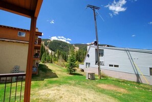 A residential area with a house, a wooden deck, and a mountain backdrop.