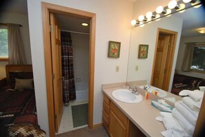 A bathroom with a sink, mirror, and towel rack.