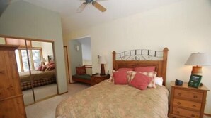 A bedroom with a bed, a nightstand, a mirror, and a wooden wardrobe. - Red Fox Town home 3 Bedroom Apartment by Key to the Rockies (Dillon)