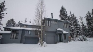 A two-story house with a garage, surrounded by snow-covered trees. - Red Fox Town home 3 Bedroom Apartment by Key to the Rockies (Dillon)