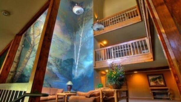 A spacious interior with a large window, a balcony, and a cozy seating area. - Snowdance Manor 2 Bedroom Holiday home by Key to the Rockies (Keystone)