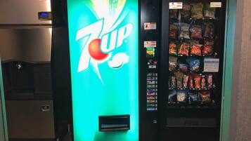 A 7UP vending machine and a refrigerator in a commercial setting.