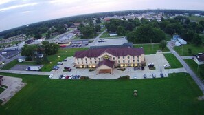 A large building with a central courtyard, surrounded by parking and greenery.
