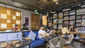 Een moderne lounge met zitplaatsen, boekenkasten en een wijnrek.