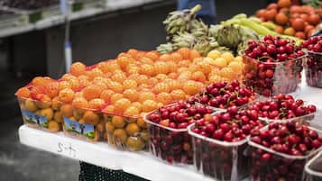 Un puesto de frutas con naranjas, limones y cerezas.