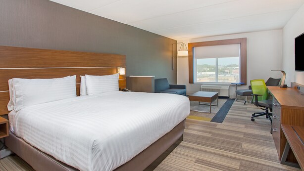A hotel room with a large bed, a desk, a chair, and a TV. - Holiday Inn Express & Suites Covington by IHG (Covington)