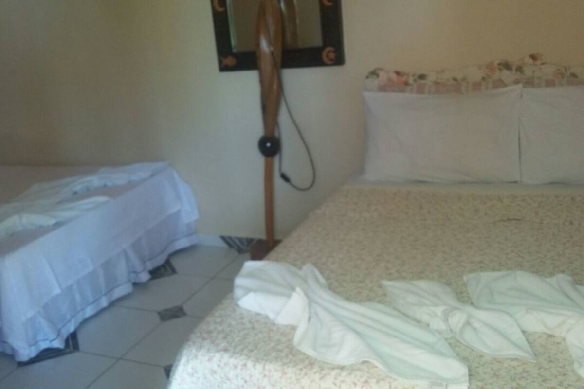 Une chambre d’hôtel avec deux lits, un miroir et une petite table.