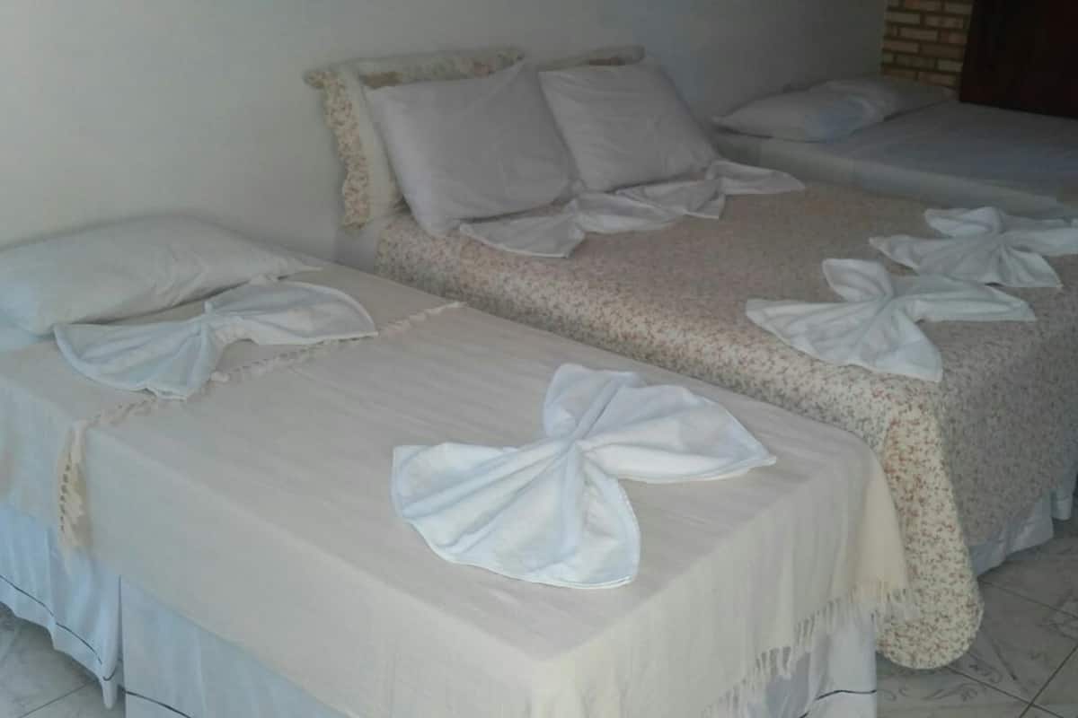 Une chambre d’hôtel avec deux lits, chacun recouvert d’une couvre-lit à motifs floraux et agrémenté d’oreillers blancs.