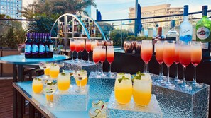 Een bar met verschillende drankjes, waaronder cocktails en alcoholvrije opties, gepresenteerd op ijs.