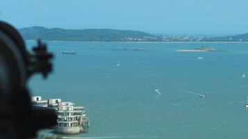 A coastal view with a marina, buildings, and a clear sky.