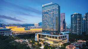 A modern hotel with a prominent InterContinental logo, surrounded by high-rise buildings and a well-lit urban environment. - Intercontinental Xiamen by IHG (Xiamen)