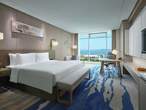 A hotel room with a large bed, a desk, and a view of the city. - Intercontinental Xiamen by IHG (Xiamen)