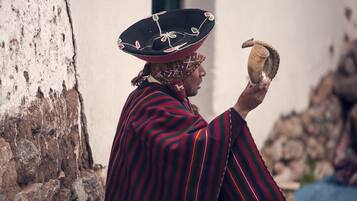 Une personne vêtue d’un costume traditionnel tenant un objet en forme de corne.