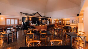 A spacious restaurant with wooden furniture, a bar area, and a high ceiling with skylights. - Double Black Hotel (Hakuba)