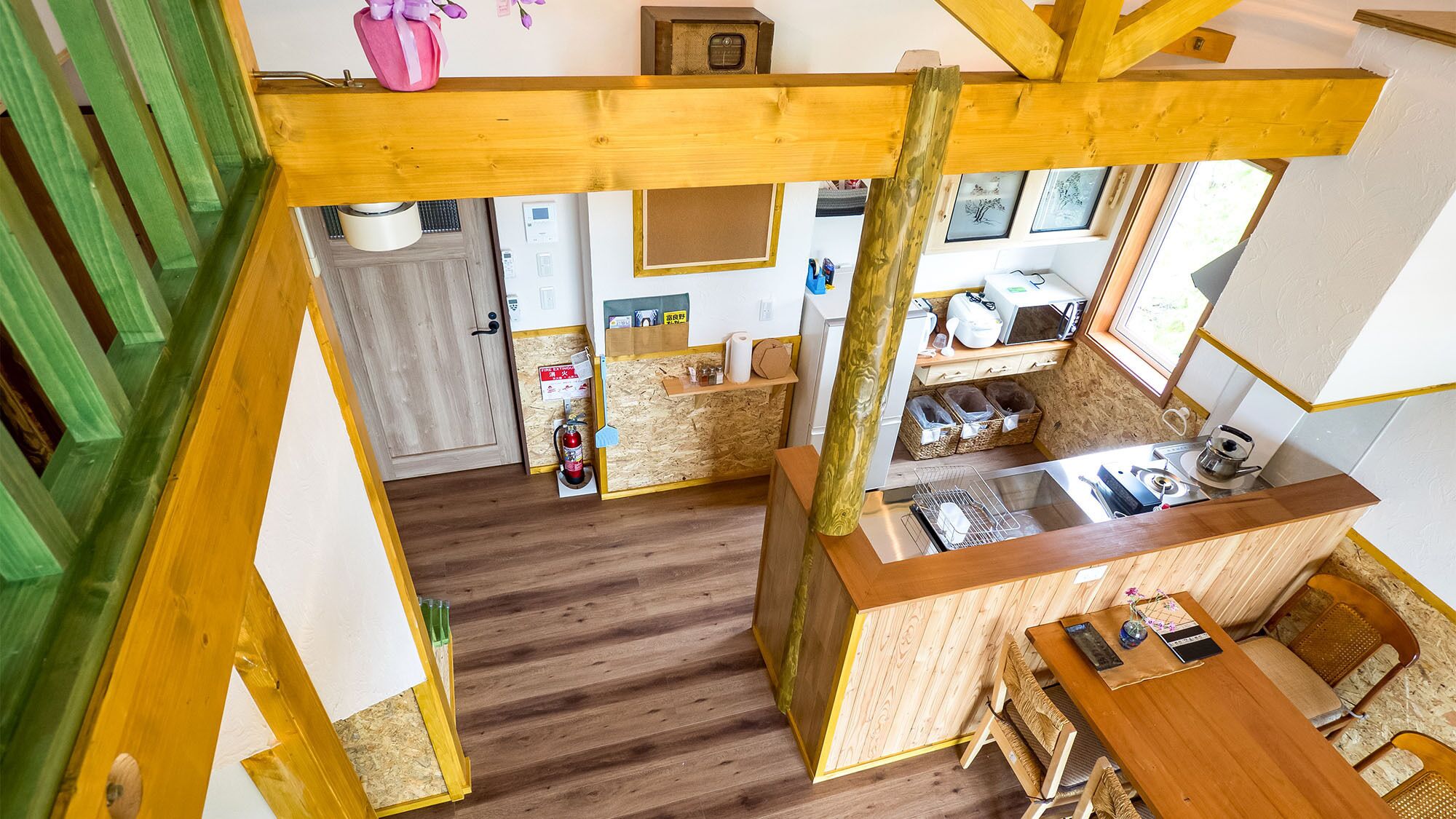 A compact kitchen with wooden beams, a built-in stove, and a small dining area with a table and chairs.