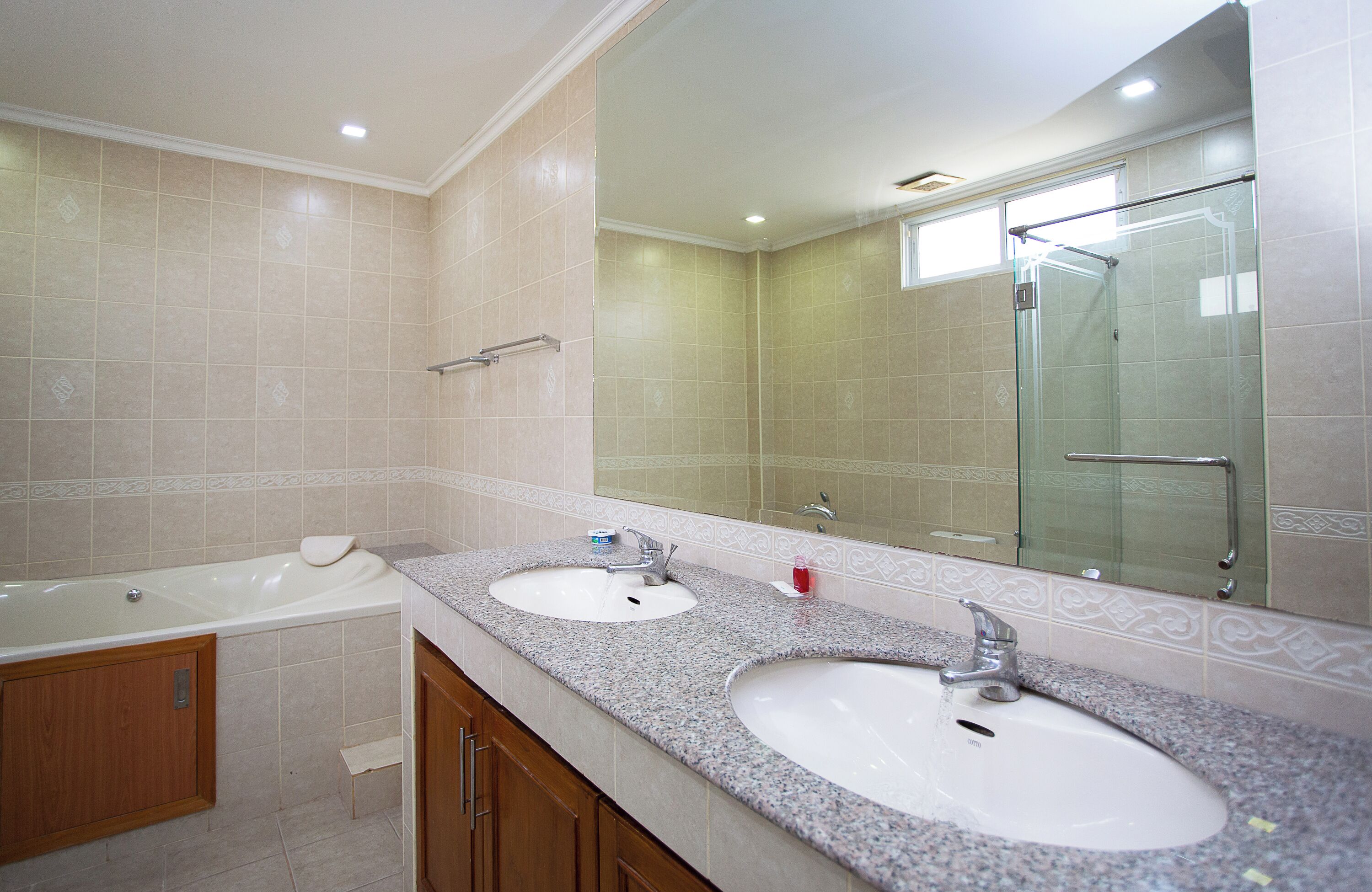 A bathroom with two sinks, a bathtub, and a glass shower enclosure.