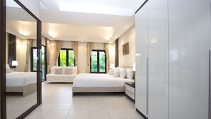 A modern hotel room with a large bed, a sofa, a desk, and a wardrobe. - Sweet Villa Pattaya (Pattaya)
