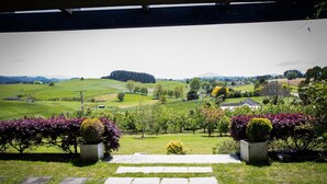 Une vue depuis un espace abrité, avec un sentier en pierre menant à un paysage rural.